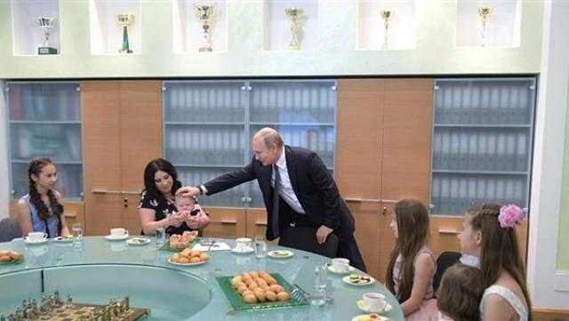 بالصورة.. الرئيس الروسي يطعم طفلًا صغيرًا على الهواء