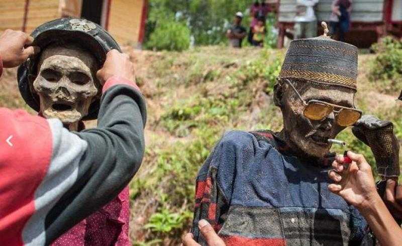 إندونيسيون ينبشون رفات موتاهم من القبور وإلباسهم الثياب لتكريمهم والتقاط صورا تذكارية