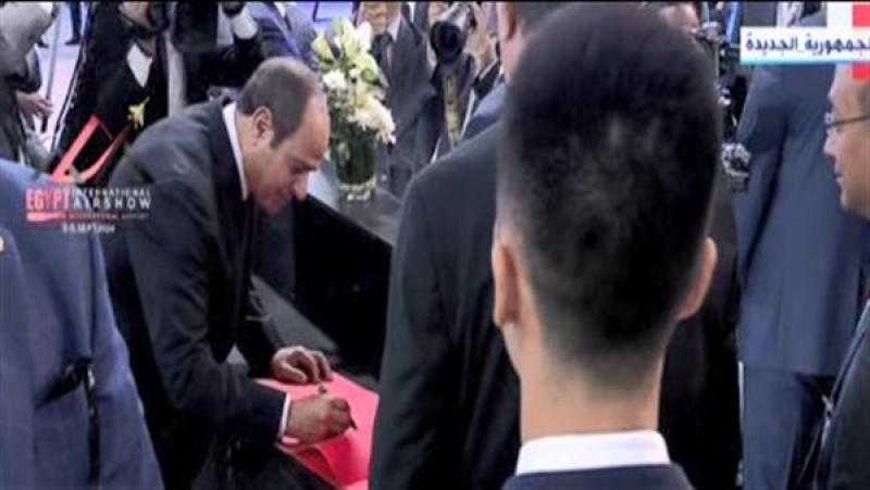 الرئيس السيسي يوقع فى سجل جناح الصين بمعرض مصر للطيران والفضاء