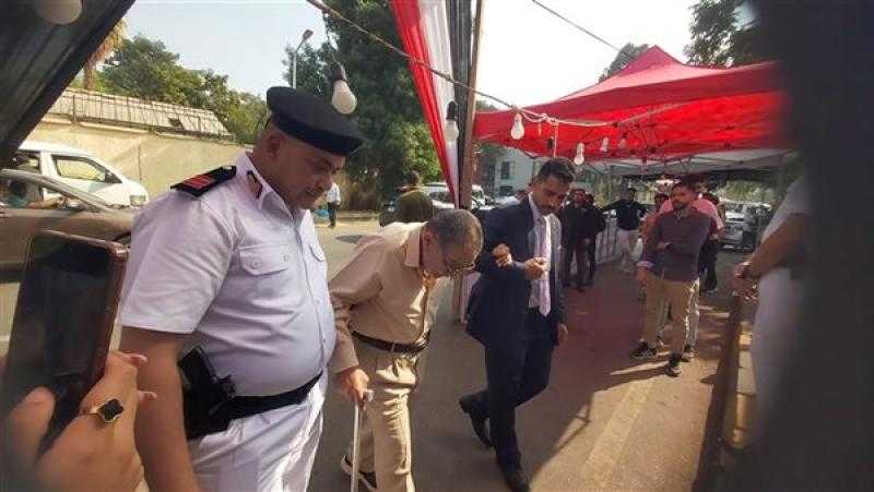 رجال الشرطة يساعدون كبار السن أمام اللجان الانتخابية بالدقي