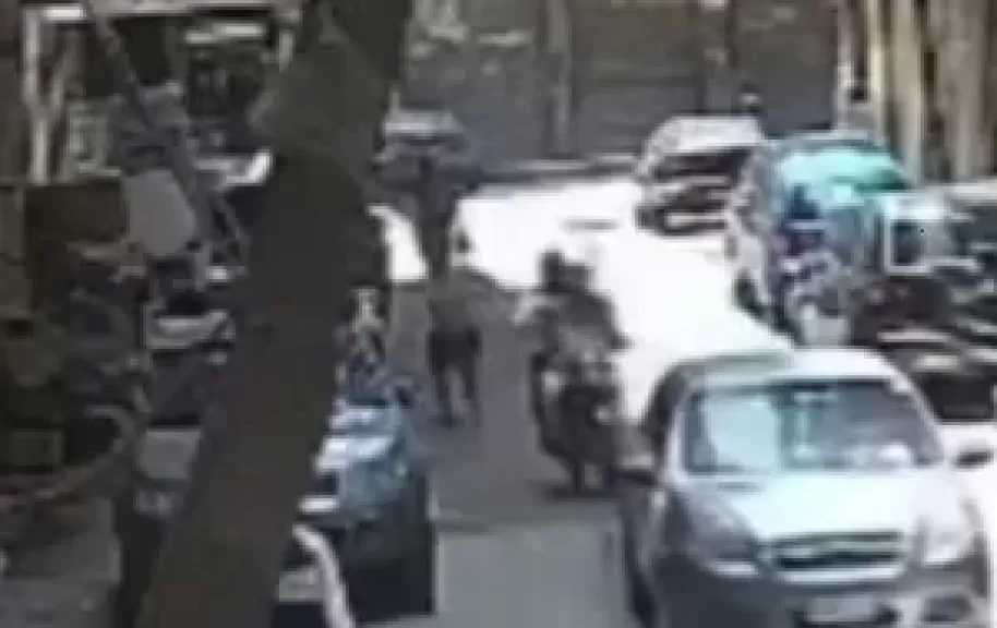 شاب يتعرض للسرقة من لصين بدراجة نارية أمام أحد البنوك